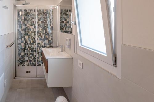 a white bathroom with a sink and a shower at Casa Quadrifoglio - Borromeo in Intra