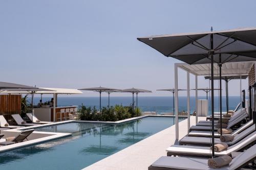 une piscine avec chaises longues et parasols dans l'établissement Maison Albar - Le Victoria, à Nice