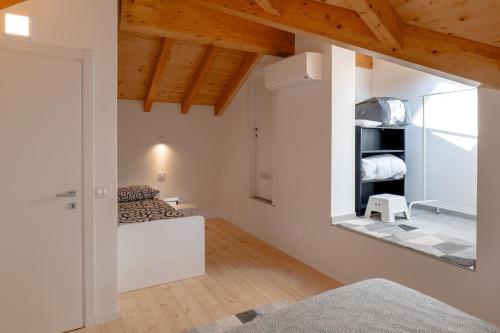 a bedroom with white walls and a mirror on the wall at Casa Quadrifoglio - Borromeo in Intra