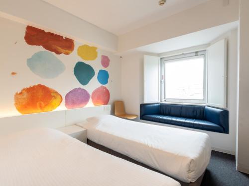 a bedroom with two beds and a couch at Hotel Art Stay Naha Kokusai-Dori in Naha