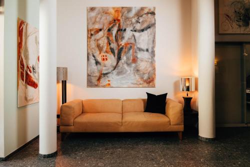 a couch in a room with a painting on the wall at Cortisen am See - Adults only in St. Wolfgang