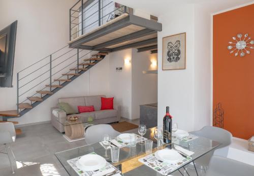 a living room with a glass table and a staircase at Casa Quadrifoglio - Borromeo in Intra