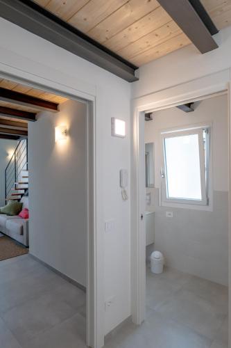 a room with white walls and a door with a window at Casa Quadrifoglio - Borromeo in Intra