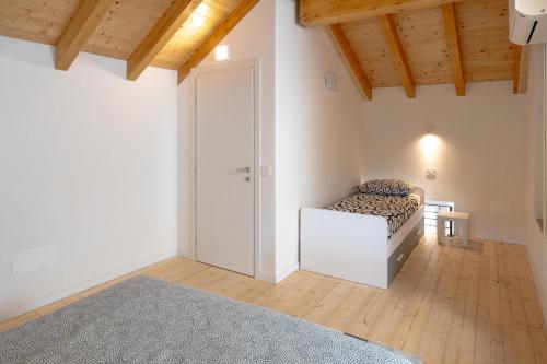 a white room with a bed and a door at Casa Quadrifoglio - Borromeo in Intra