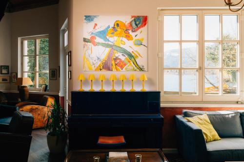 a living room with a fireplace and a painting at Cortisen am See - Adults only in St. Wolfgang