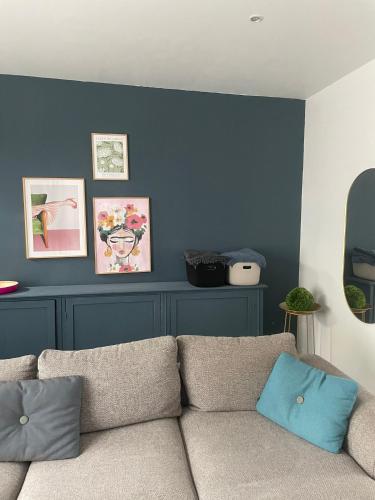 a living room with a couch and a blue wall at Kleine Dijk in Diksmuide
