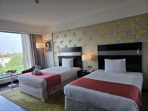 a hotel room with two beds and a window at Crowne Plaza Pune City Centre by IHG in Pune