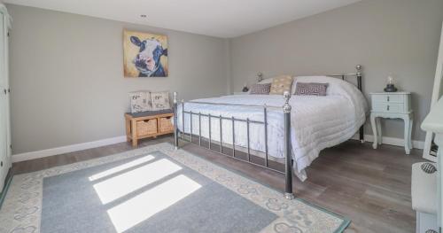 a bedroom with a large bed and a rug at Gorgeous rural dog welcoming Milk Churn - Suffolk in Eye