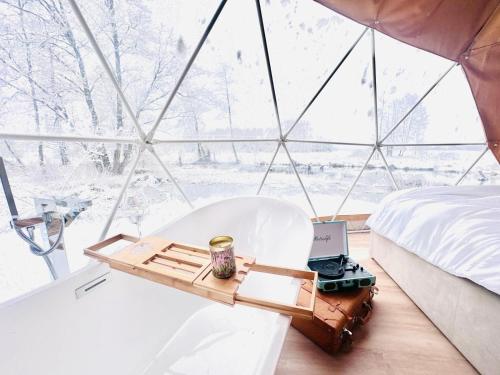 a bed and a table with a laptop in a tent at Heaven Reset Spa Luksusowy Glamping Jacuzzi w Naturze Blisko Warszawy in Korczew