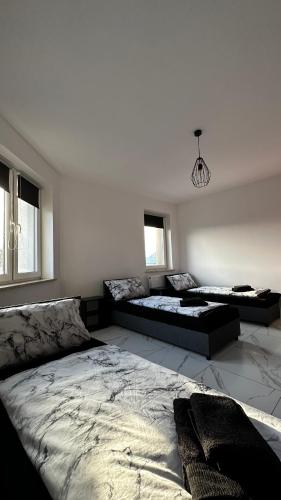 a bedroom with two beds and a couch at Mieszkanie na wyłączność in Radomsko