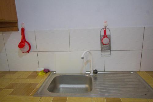 a kitchen with a sink and a clock on the wall at Havillah Gardens Watamu in Watamu
