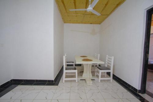 a table and chairs in a room with a ceiling at Havillah Gardens Watamu in Watamu