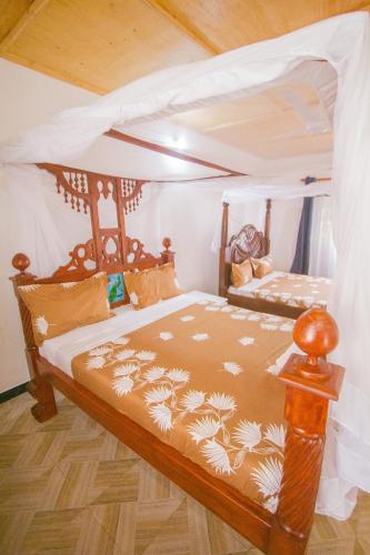a bedroom with a bed with a canopy at Havillah Gardens Watamu in Watamu