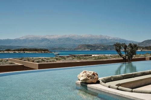 a swimming pool with a rock in the water at JW Marriott Crete Resort & Spa in Marathi