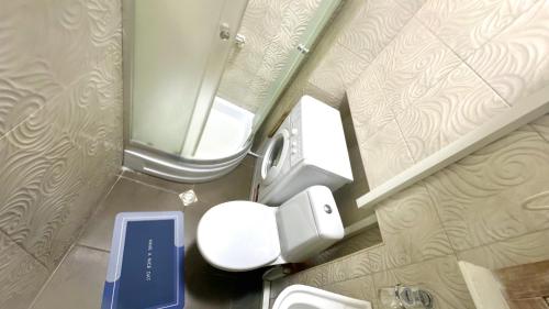 Un pequeño baño con inodoro y espejo. en Cloudy Tbilisi Apartment, en Tiflis