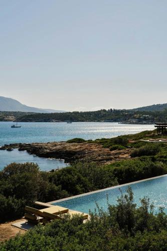 a swimming pool with a view of a body of water at JW Marriott Crete Resort & Spa in Marathi