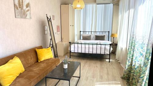 una sala de estar con un sofá y una cama en Cloudy Tbilisi Apartment, en Tiflis