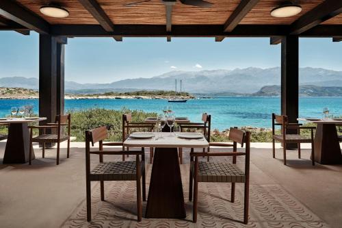 a dining room with a table and chairs and the ocean at JW Marriott Crete Resort & Spa in Marathi