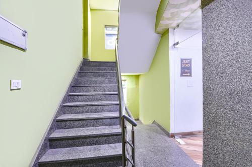 a hallway with stairs in a building with green walls at FabExpress Jeet Stays - Near Dilshad Garden Metro Station in New Delhi