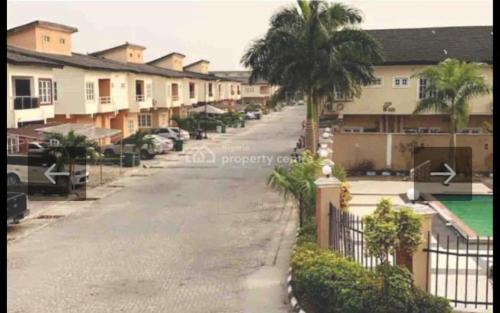 an empty street with houses and a palm tree at Peace Home in Lekki