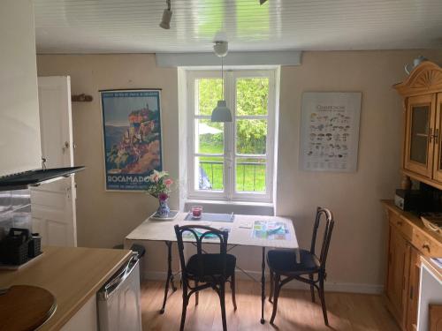une cuisine avec une table et des chaises et une fenêtre dans l'établissement No 2 route de la maronne, Loupiac la Gare, à Loupiac La Gare