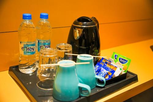 a tray with bottles of water and glasses on a table at THE CENT HOTEL in Hyderabad