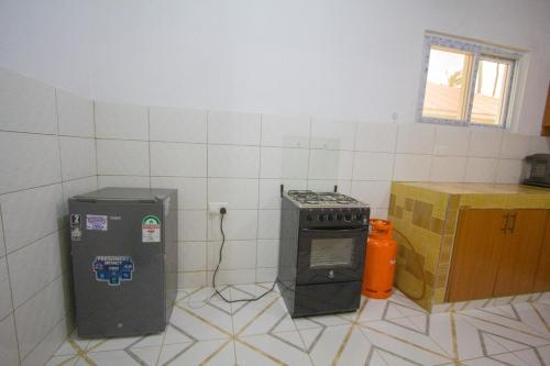 a kitchen with a stove and a trash can at Havillah Gardens Watamu in Watamu