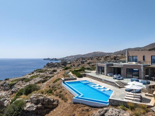 an image of a house with a swimming pool at Seafront elegant villas, with infinity pools & devine views! in Agios Pavlos