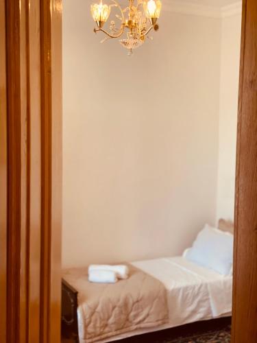 a small bedroom with a bed and a chandelier at House of Warmth in Bagdatʼi
