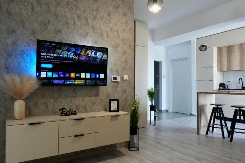 a kitchen and living room with a tv on the wall at Flat in Otopeni in Otopeni