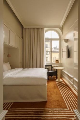 a hotel room with a bed and a window at Stockholm Stadshotell in Stockholm