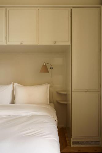 a bedroom with a white bed and white cabinets at Stockholm Stadshotell in Stockholm
