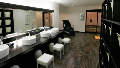 Un baño con lavabos, taburetes y un espejo. en Green Rich Hotel Matsue Ekimae, en Matsue