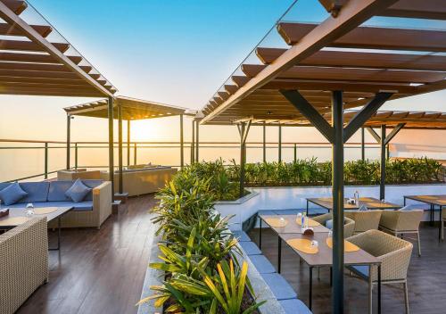 an outdoor patio with tables and chairs and plants at Bloom Boutique - Rishikesh Hills in Rishīkesh