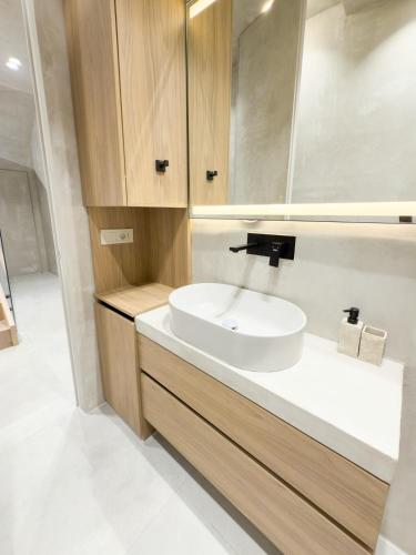 a bathroom with a white sink and a mirror at Villa 4 - Drymades - Thymus Residence in Dhërmi