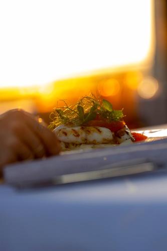 a person holding a plate of food on a table at Grand Hotel Forlì in Forlì