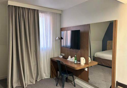 a hotel room with a desk and a bed at B&B HOTEL Le Havre Centre in Le Havre