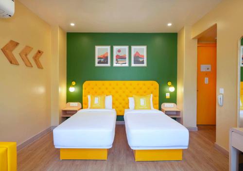 two beds in a room with green walls at Bloom Boutique - Rishikesh Hills in Rishīkesh