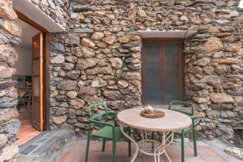 a table and chairs on a patio with a stone wall at Off-Grid - Puerto Mika in Órgiva