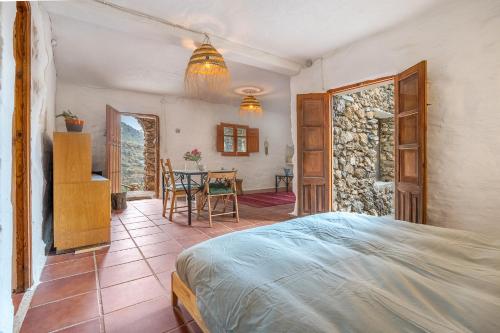a bedroom with a bed and a table at Off-Grid - Puerto Mika in Órgiva