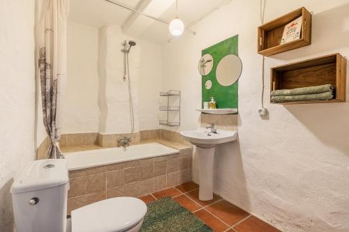 a bathroom with a toilet and a sink and a tub at Off-Grid - Puerto Mika in Órgiva