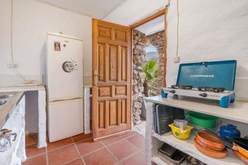 a kitchen with a refrigerator and a stove at Off-Grid - Puerto Mika in Órgiva