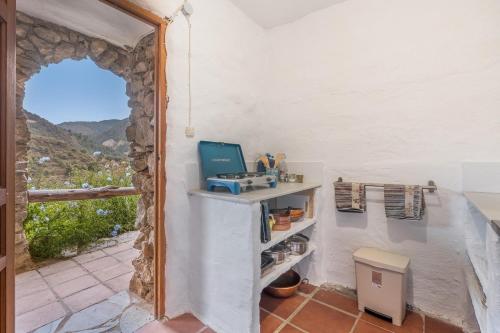 a room with a window and a table with a computer at Off-Grid - Puerto Mika in Órgiva