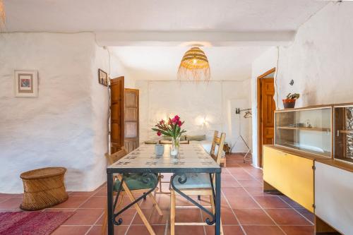 a kitchen with a table with flowers on it at Off-Grid - Puerto Mika in Órgiva