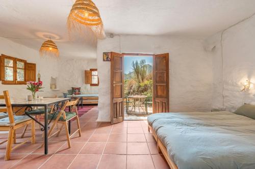 a bedroom with a bed and a table and a dining room at Off-Grid - Puerto Mika in Órgiva