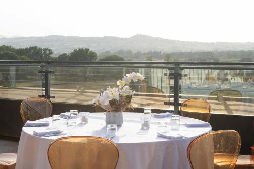 a table with a vase of flowers on a balcony at Grand Hotel Forlì in Forlì