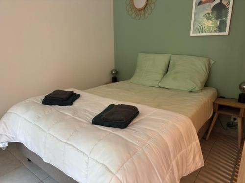 a bedroom with a bed with two towels on it at Apt 4 people pool air conditioning garden in Mandelieu-la-Napoule