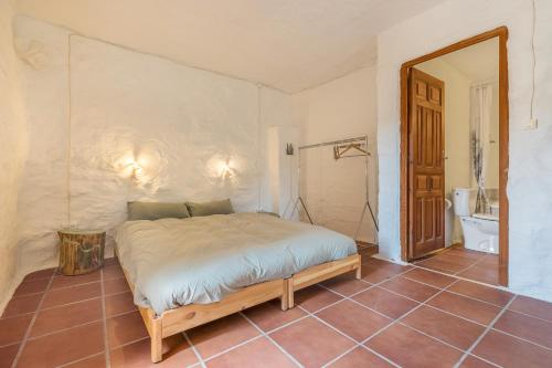 a bedroom with a bed and a tiled floor at Off-Grid - Puerto Mika in Órgiva