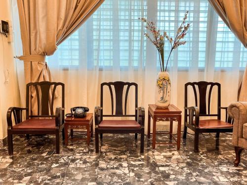 a room with four chairs and a table with a vase at Lasam Heritage Villa 22pax with Karaoke & Snooker in Ipoh