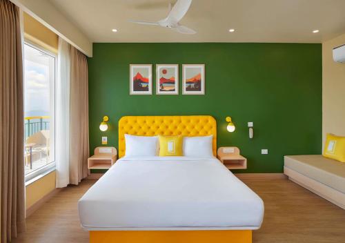 a bedroom with a large bed and a green wall at Bloom Boutique - Rishikesh Hills in Rishīkesh